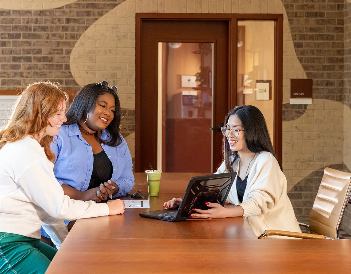 a group of young adults looking at a laptop